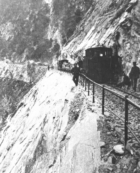 25-BLS-Süd-Dienstbahnzug-in-den-Felsen-der-Bietschtalostseite.-Heute-Wanderweg.-Archiv-BLS-1-830x1024.jpg