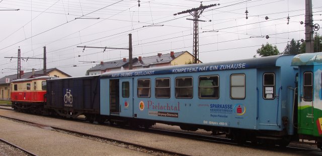 En gare de Mariazell un train vient d'arriver avec un fourgon transport de vélos et une BD4ipho en livrée publicitaire